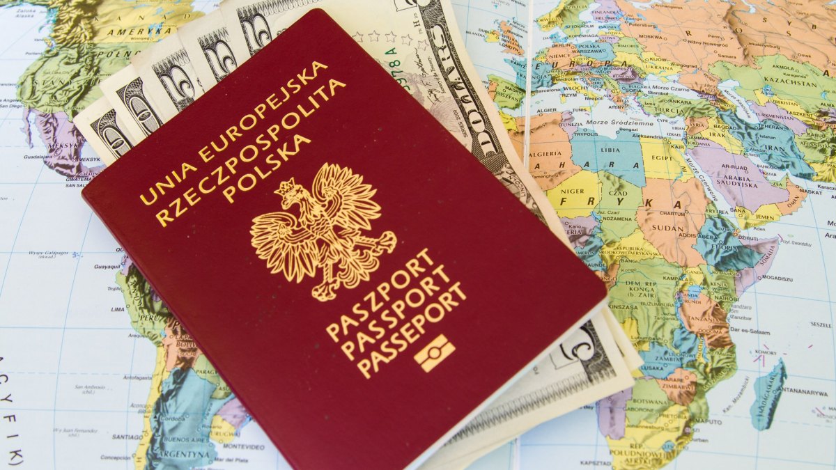 Red passports and money (polish zloty and dollars) over map background