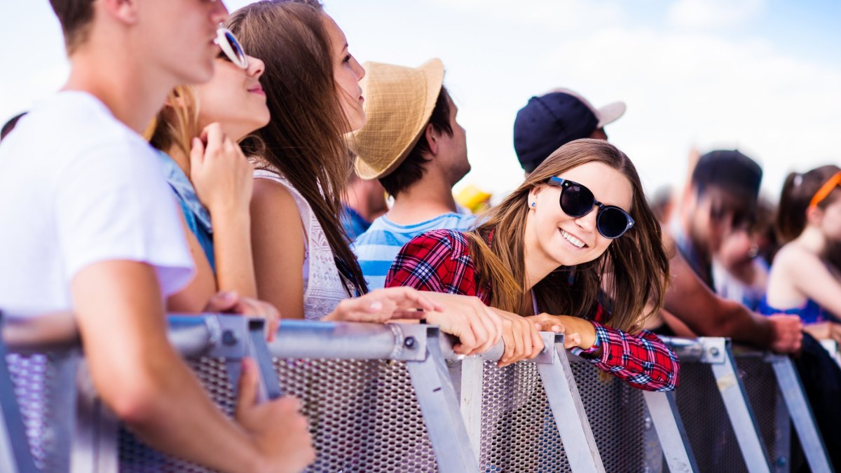 Teenagers at summer music festival, at the barrier